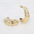 Gouden stainless steel oorringen met glanzende geribbelde afwerking.