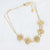 Gouden stainless steel ketting met dubbele ketting en vijf gehamerde ronde schijven.