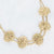 Gouden stainless steel ketting met dubbele ketting en vijf gehamerde ronde schijven.