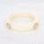 Beige resin bangle met twee zirconia-steentjes in goudkleurige omlijsting.