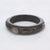Bruine resin bangle met twee zirconia-steentjes in goudkleurige omlijsting.