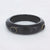 Zwarte resin bangle met twee zwarte zirconia-steentjes in goudkleurige omlijsting.