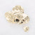 Gouden stainless steel broche met glanzende, organisch gevouwen vorm.