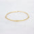 Gouden stainless steel bangle met subtiele kabelstructuur en ringdetail in het midden.