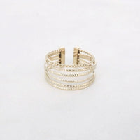 Goudkleurige stainless steel ring met meerdere smalle bandjes en gedraaide details, verstelbaar design.