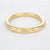 Gouden stainless steel bangle met gladde, glanzende afwerking in vaste vorm.