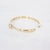 Gouden stainless steel bangle met vloeiende organische vorm en kliksluiting.