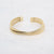 Gouden stainless steel open bangle met dubbele band en fijne ribbelstructuur.